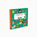 A children's activity book titled 'Magnéti stories' shown at a slight angle on a plain light background. The cover is predominantly teal green with colorful cartoon illustrations including a scarecrow, pumpkin, bird, fruit, basket, and animal characters.