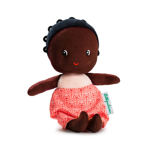 Stuffed toy with dark skin, black hair, and red patterned pants on a white background