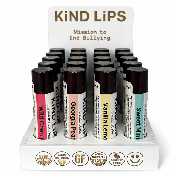 Display of Kind Lips lip balm tubes with a mission statement on a white background