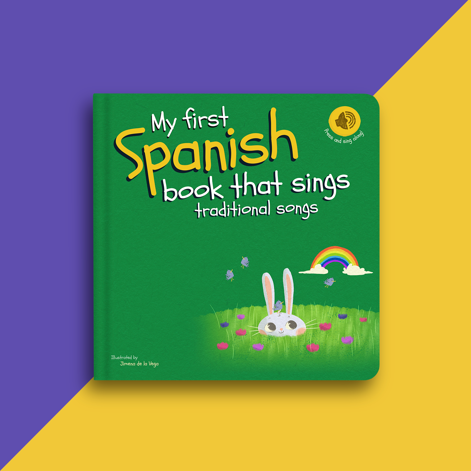 A children's hardcover book titled "My first Spanish book that sings traditional songs" shown on a split purple and yellow background. The cover is predominantly green with large yellow and white title text, a white bunny, grass, flowers, a rainbow, and small purple butterflies.