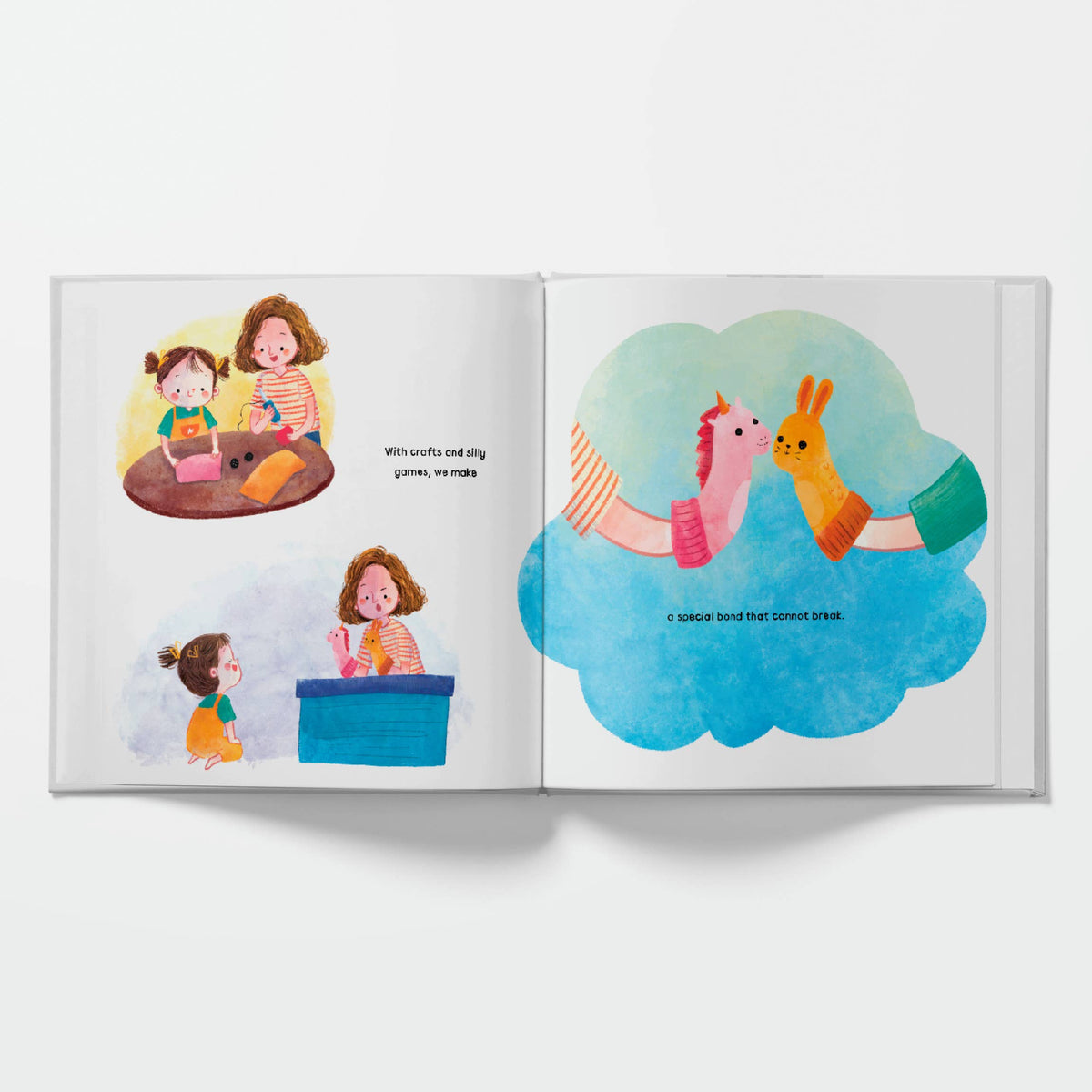 An open children's picture book with two illustrated spread pages, photographed against a clean white background. The left page shows two children at a table, and the right page features a large blue cloud illustration with a pink llama and a yellow rabbit.
