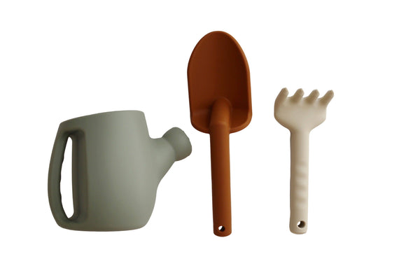 Set of gardening tools including a watering can, shovel, and rake on a white background
