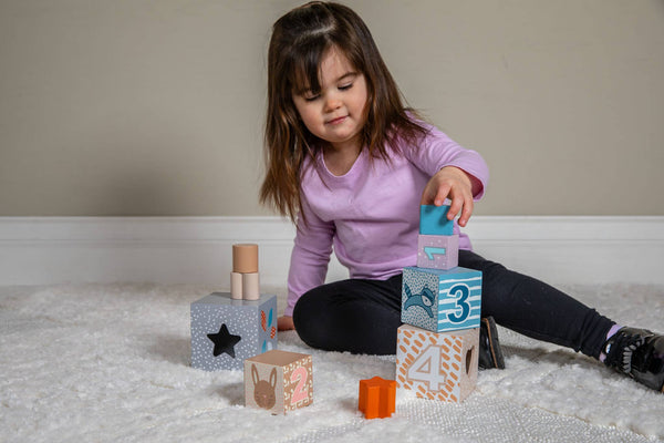 Child playing with colorful blocks on a carpeted floor