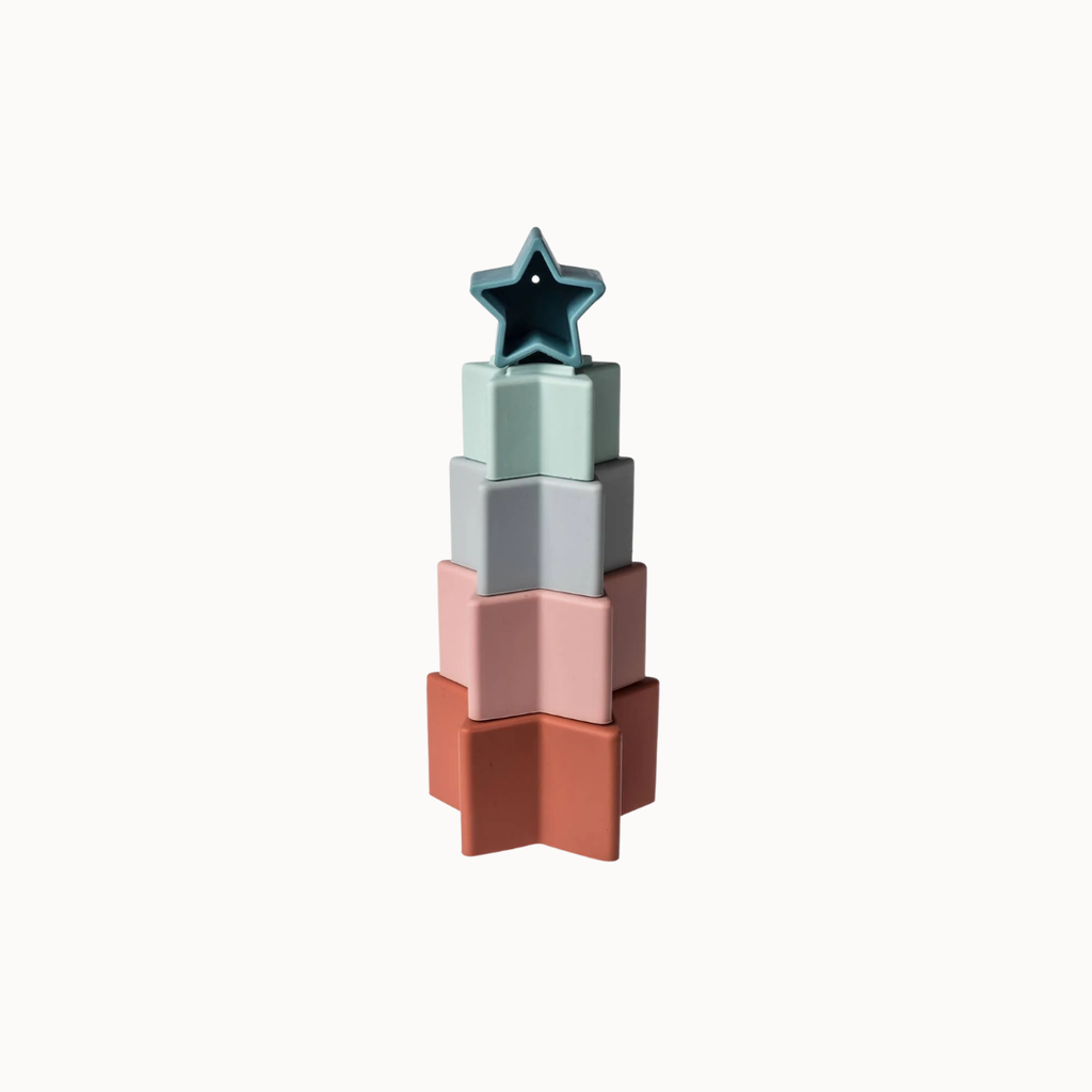 A set of five nested, tiered star-shaped cookie cutters in pastel colors, including terracotta, dusty pink, light gray, mint green, and dark teal, arranged on a solid off-white background.