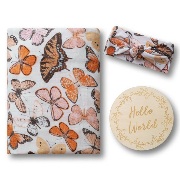 Butterfly-patterned baby blanket, headband, and 'Hello World' wooden disc on a white background