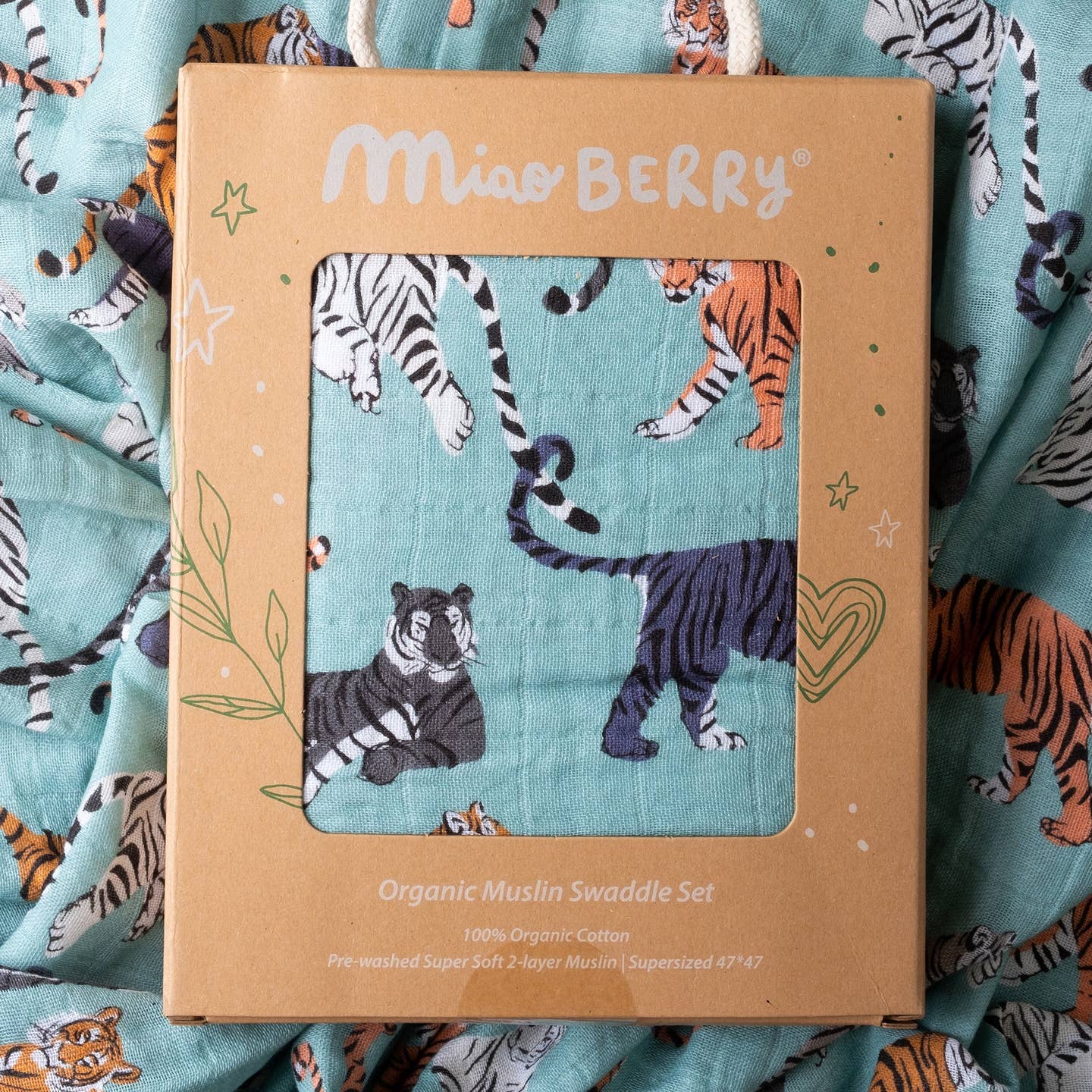 Miao Berry organic muslin swaddle set packaging with tiger design on a fabric background