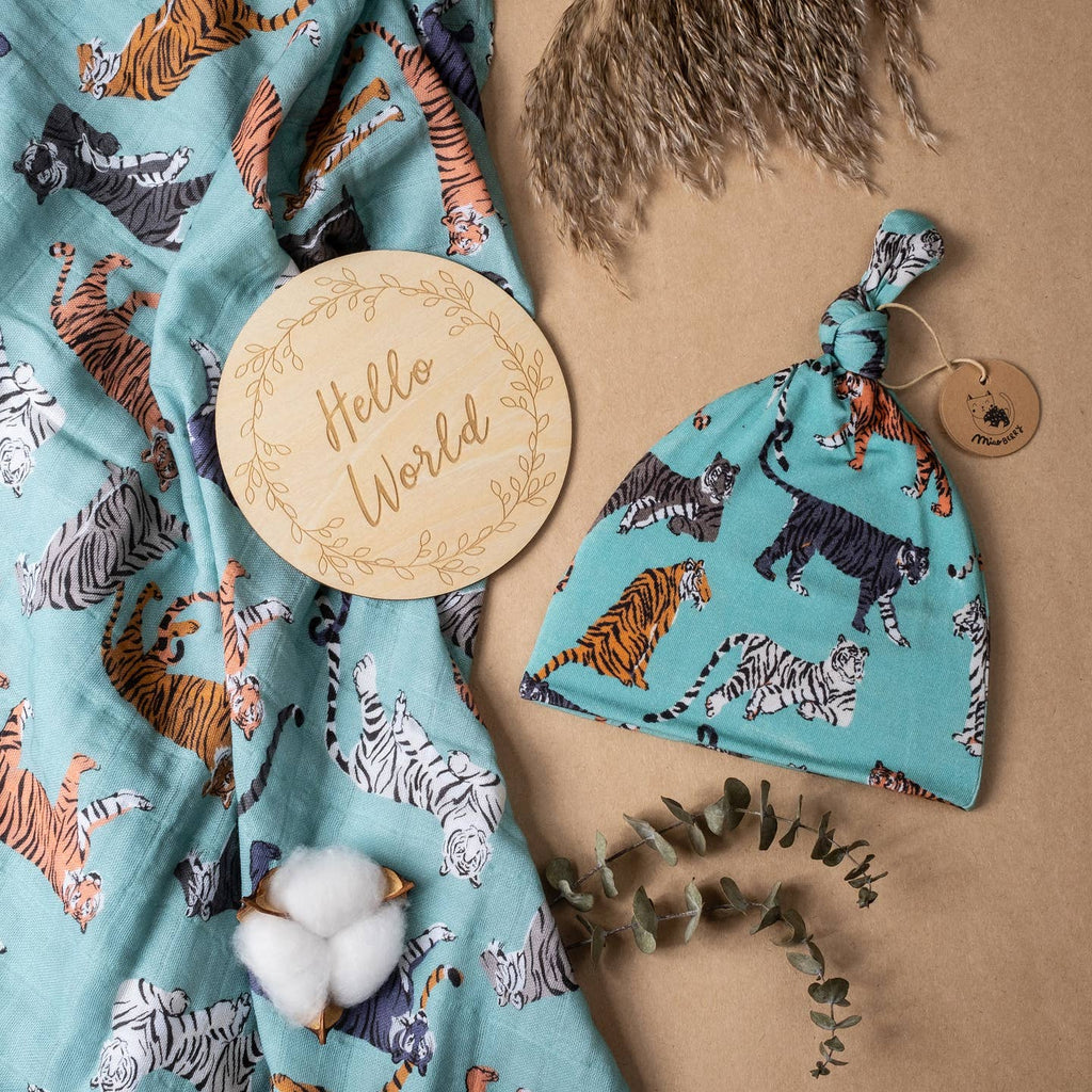Baby hat and blanket with tiger pattern on a brown background
