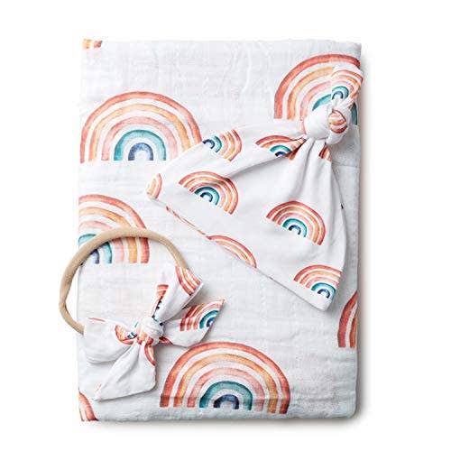 Baby blanket with rainbow pattern and teething ring on a white background