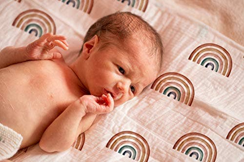 Baby lying on a blanket with rainbow patterns
