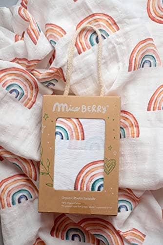 Baby blanket with rainbow pattern and a package labeled 'Miss Berry' on top