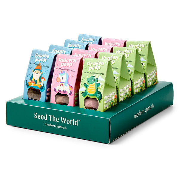Display of colorful seed packages with cartoon characters on a green stand, featuring the brand 'modern sprout'.