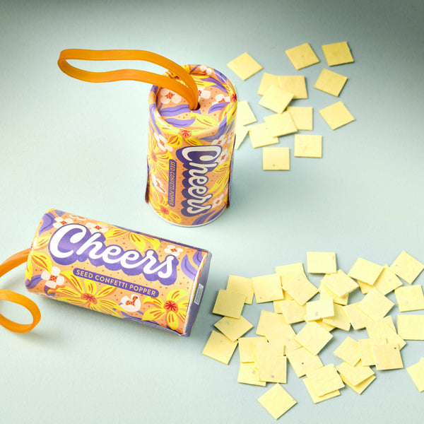 Cheers seed confetti popper with yellow squares on a light gray background