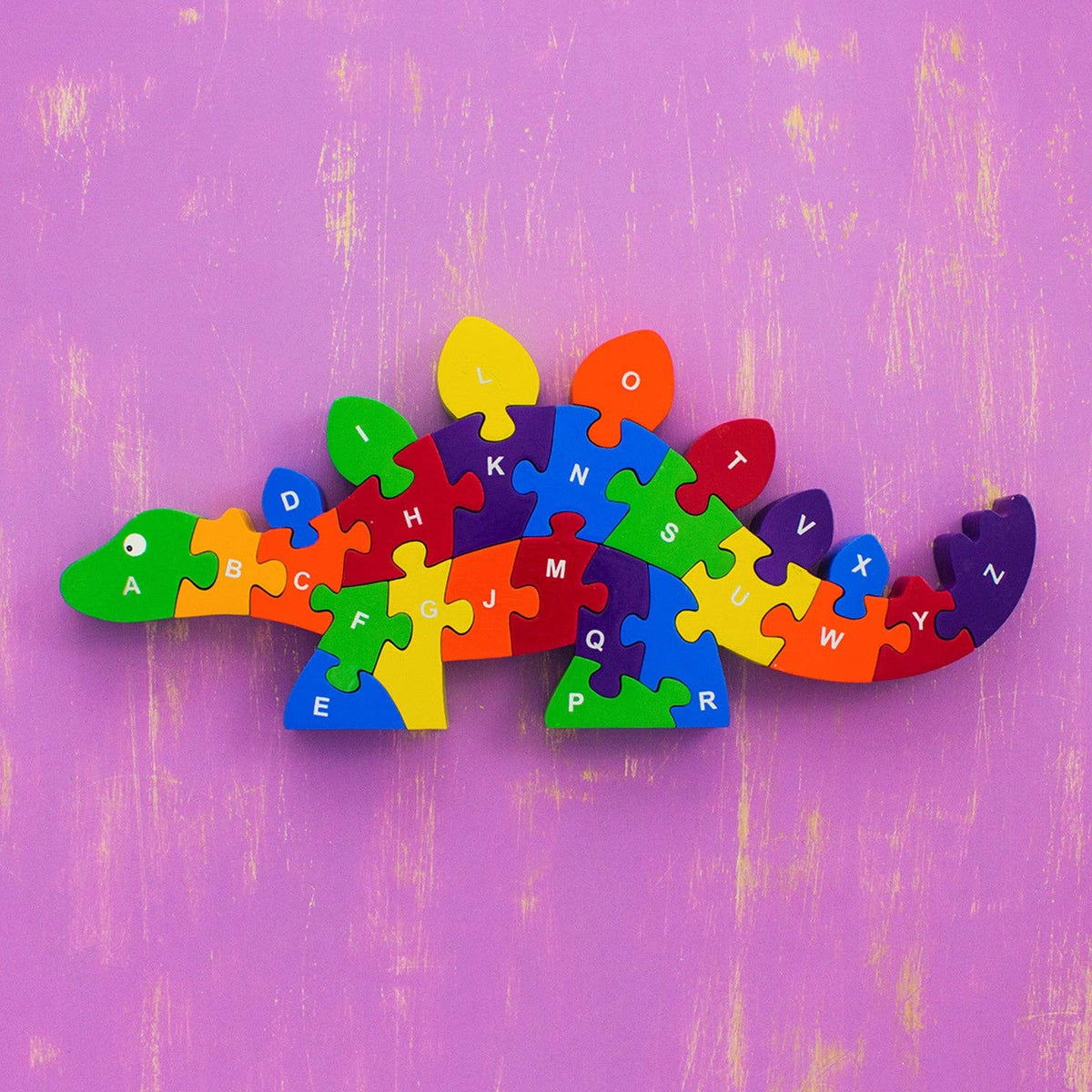 Rainbow colored wooden dinosaur puzzle on a white background