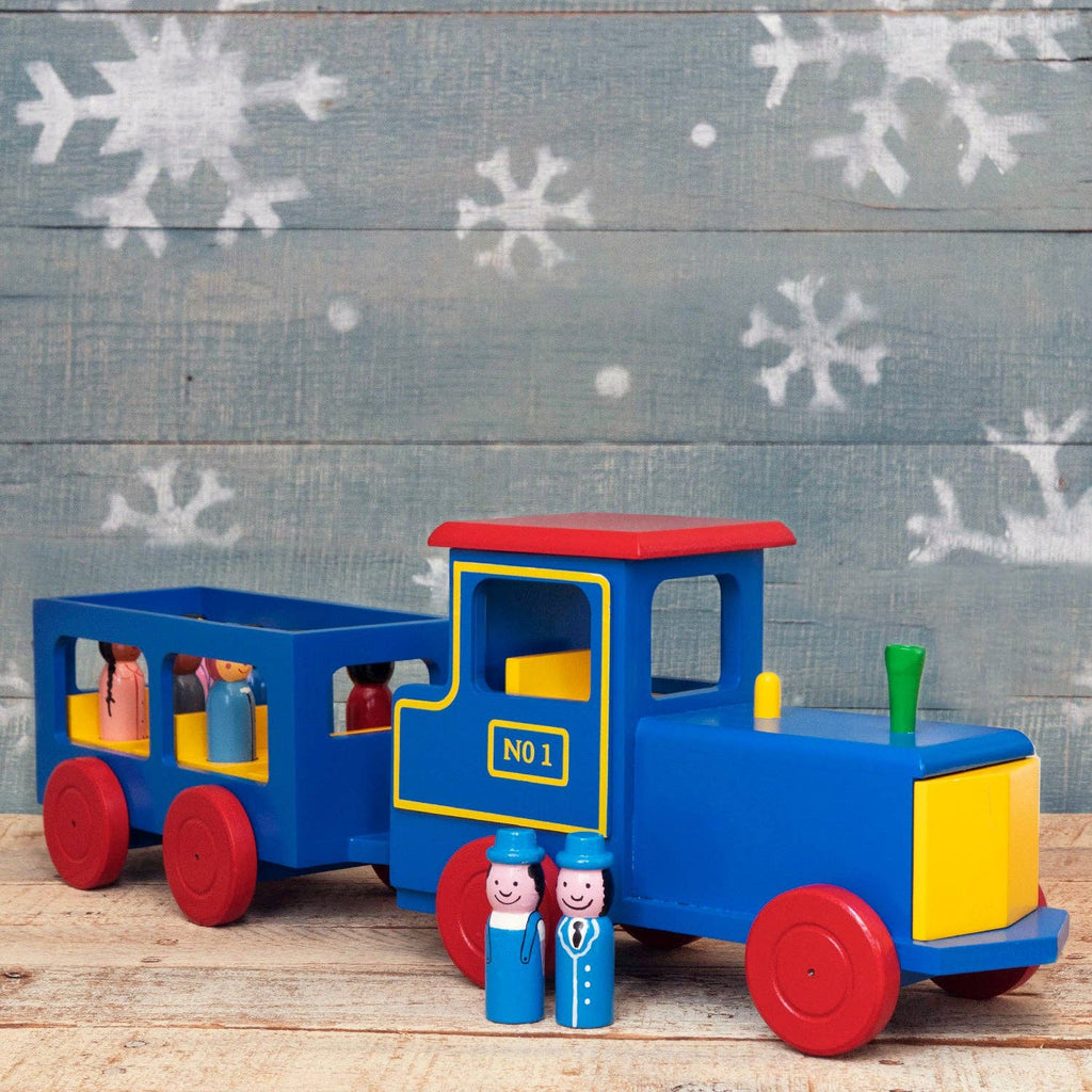 Colorful toy train with two figures on a wooden surface and snowy background