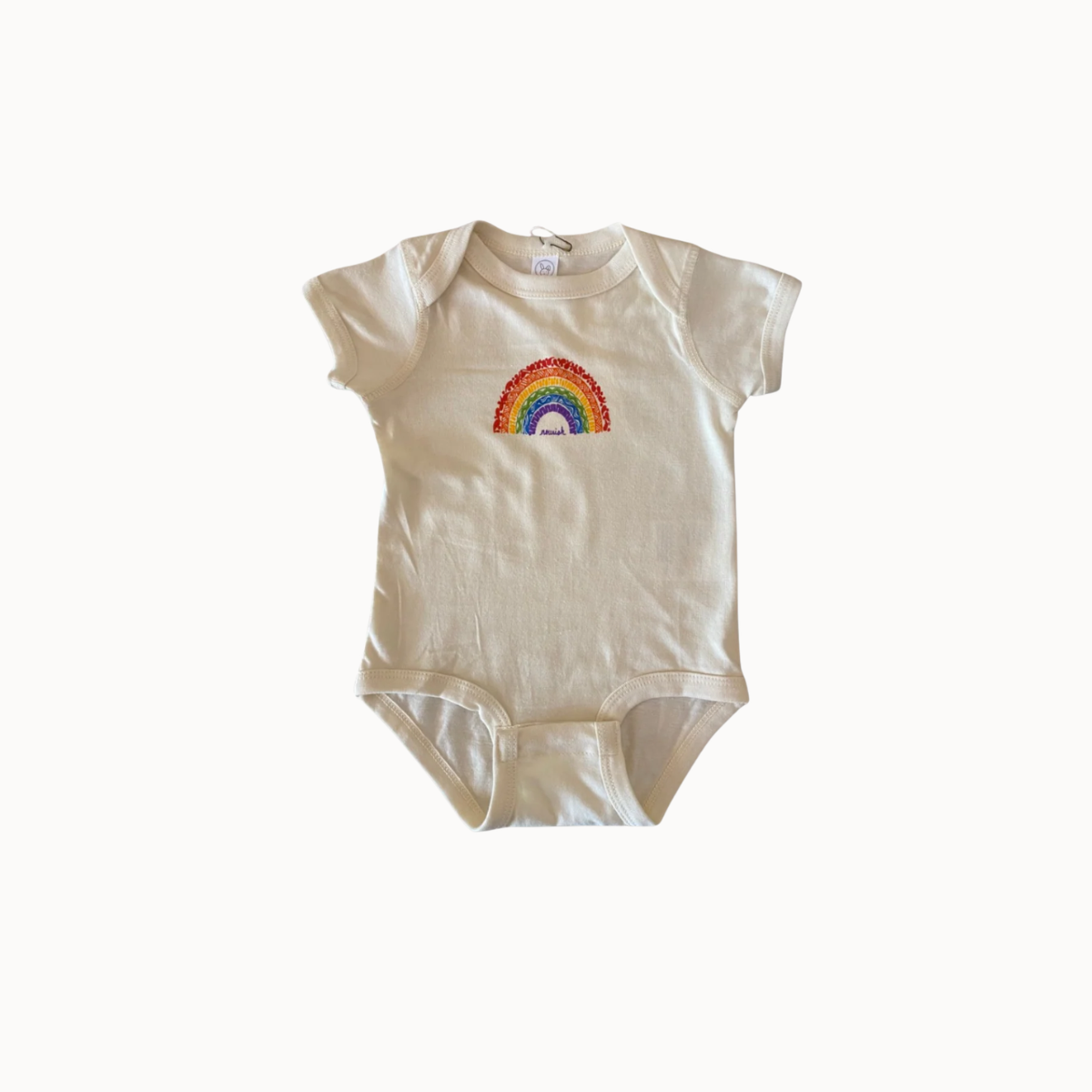 A short-sleeve baby bodysuit in cream-colored cotton, featuring a colorful embroidered rainbow with a white sun and blue sky motif on the chest, displayed against a plain white background.
