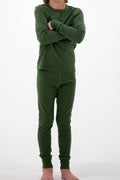 A child wearing a matching dark green long-sleeve top and pants set, standing with arms crossed against a plain white background.