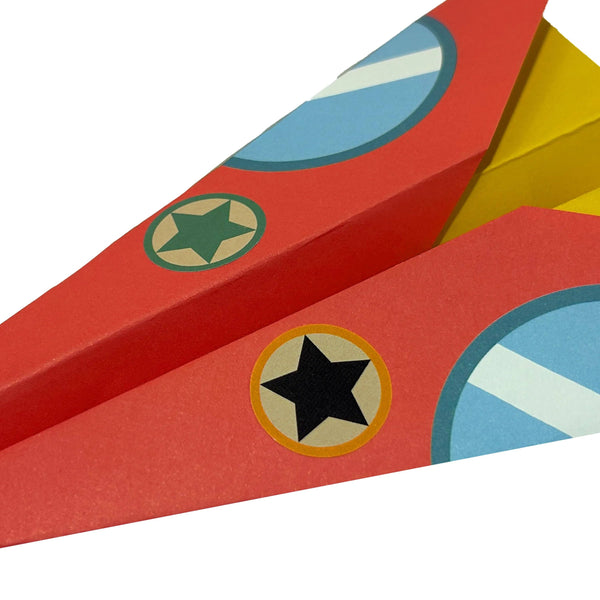 Colorful paper airplanes with star and circle designs on a white background
