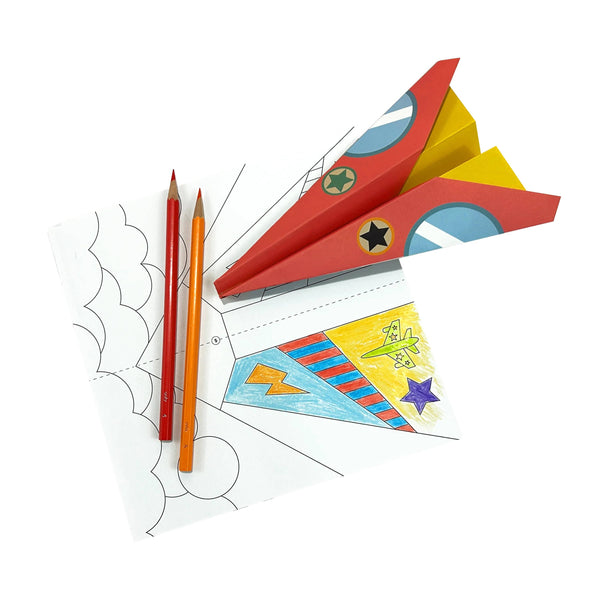 Colorful paper rocket model with pencils and templates on a white background