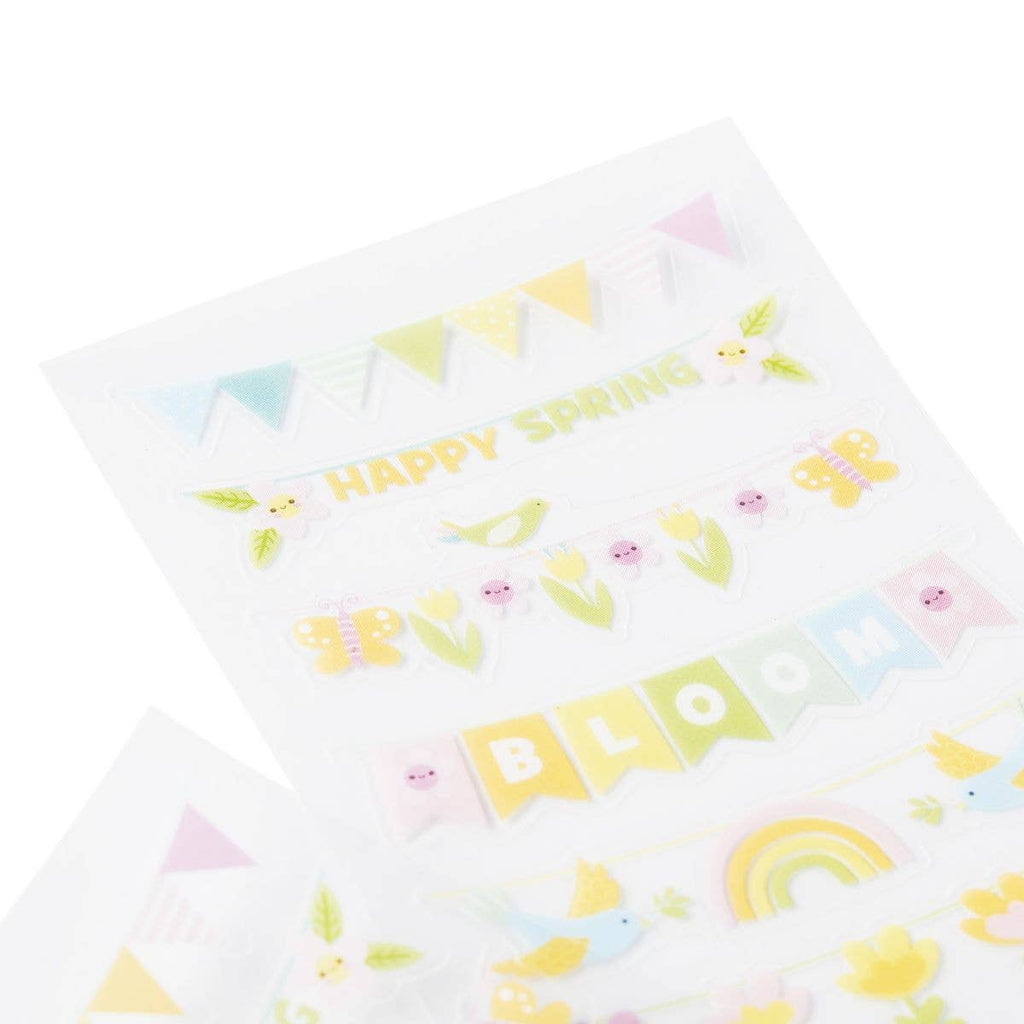 White pillow with colorful spring-themed patterns on a white background