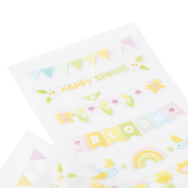 White pillow with colorful spring-themed patterns on a white background
