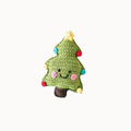 A green crocheted Christmas tree plush toy with embroidered facial features, colorful yarn ornaments, and a brown trunk, centered on a plain white background.