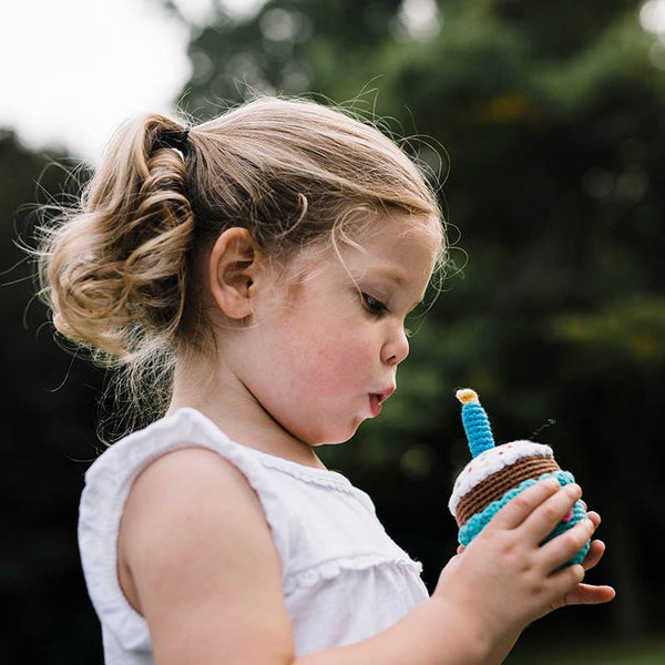 Child holding a toy ice cream cone outdoors