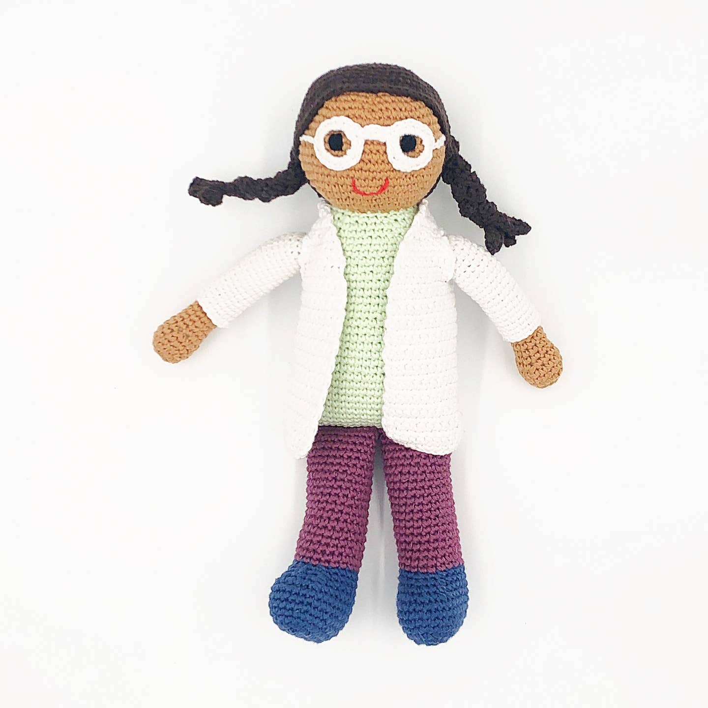 Crocheted doll with a white lab coat, green shirt, purple pants, and blue shoes on a white background