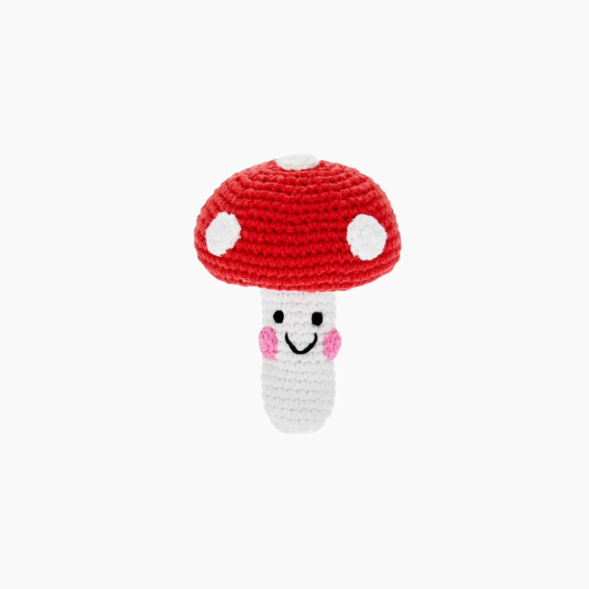 A crocheted mushroom toy with a red cap, white spots, a white stem, and a smiling face with pink cheeks, centered on a light gray background.