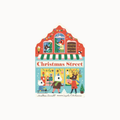 Children's board book cover titled 'Christmas Street' featuring a colorful illustrated storefront with holiday characters and decorations on a light gray background.