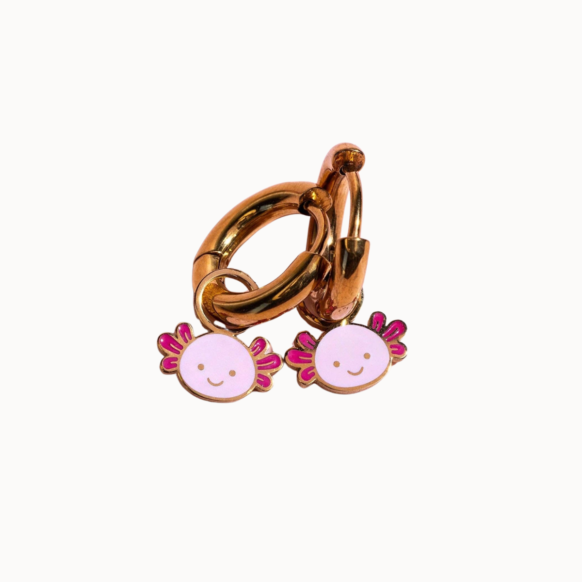 A gold-toned metal key ring accessory with two dangling pink and lavender enamel axolotl charms, shown on a plain white background.