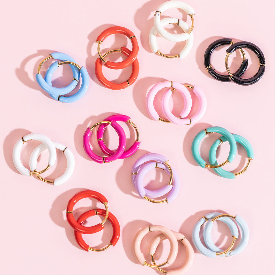 Colorful circular earrings on a pink background