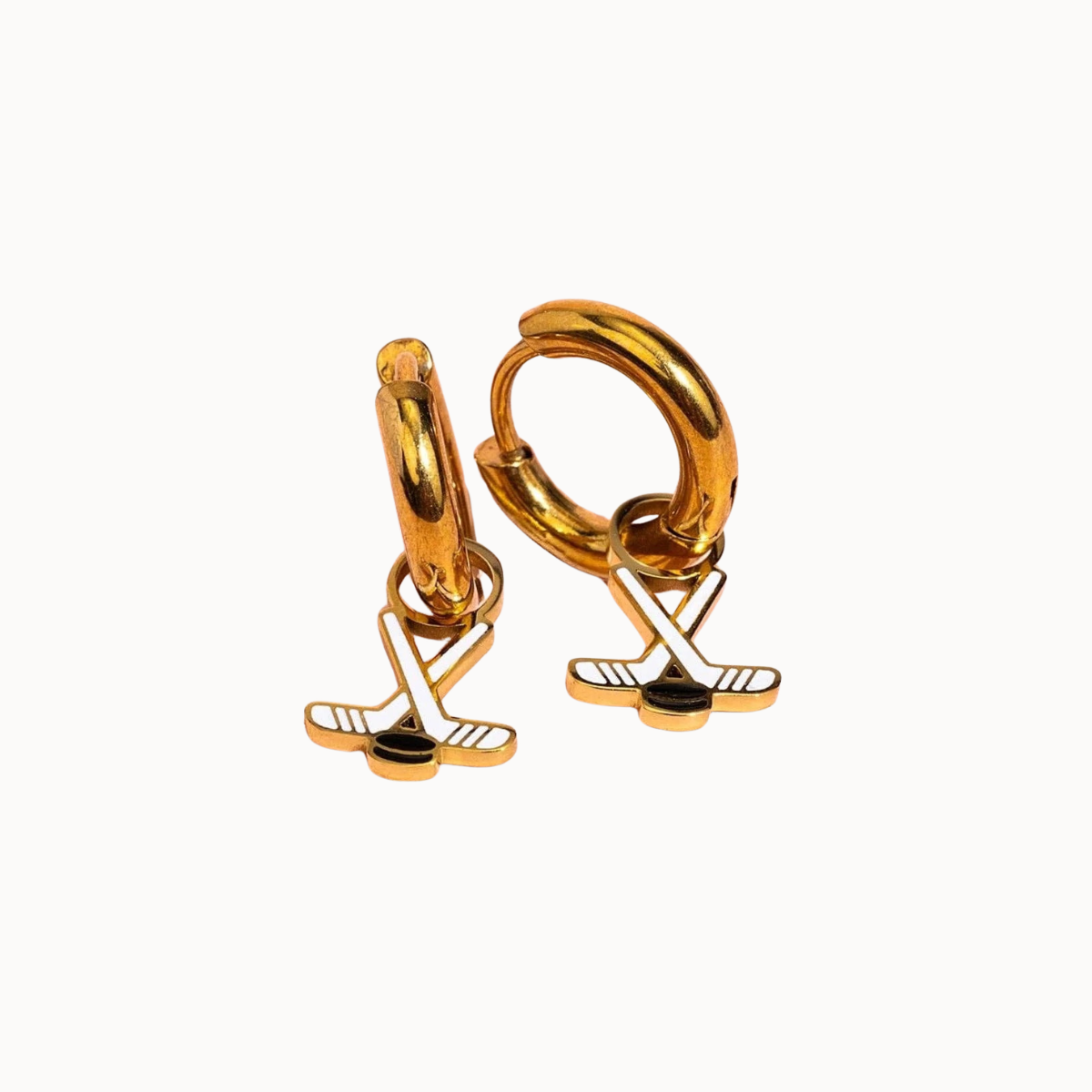 Gold huggie hoop earrings with a dangling golf club and golf ball charm, shown on a plain off-white background.