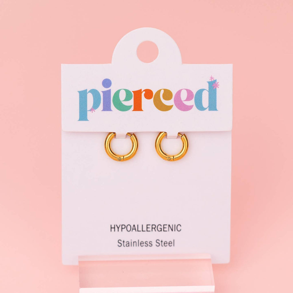 A pair of gold hoop earrings displayed on a white Pierced brand card against a soft pink background.