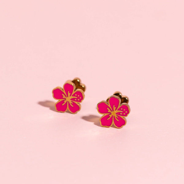Flower-shaped earrings on a pink background