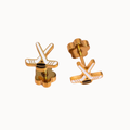 A pair of gold-toned stud earrings shaped like stylized hockey sticks with white accents, shown on a plain light background.