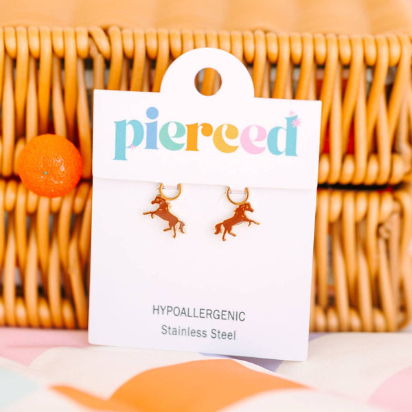 Earring card with horse-shaped earrings on a wicker surface