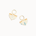 A pair of gold-tone menorah-shaped earrings with light blue and orange enamel details, displayed on a solid off white background.