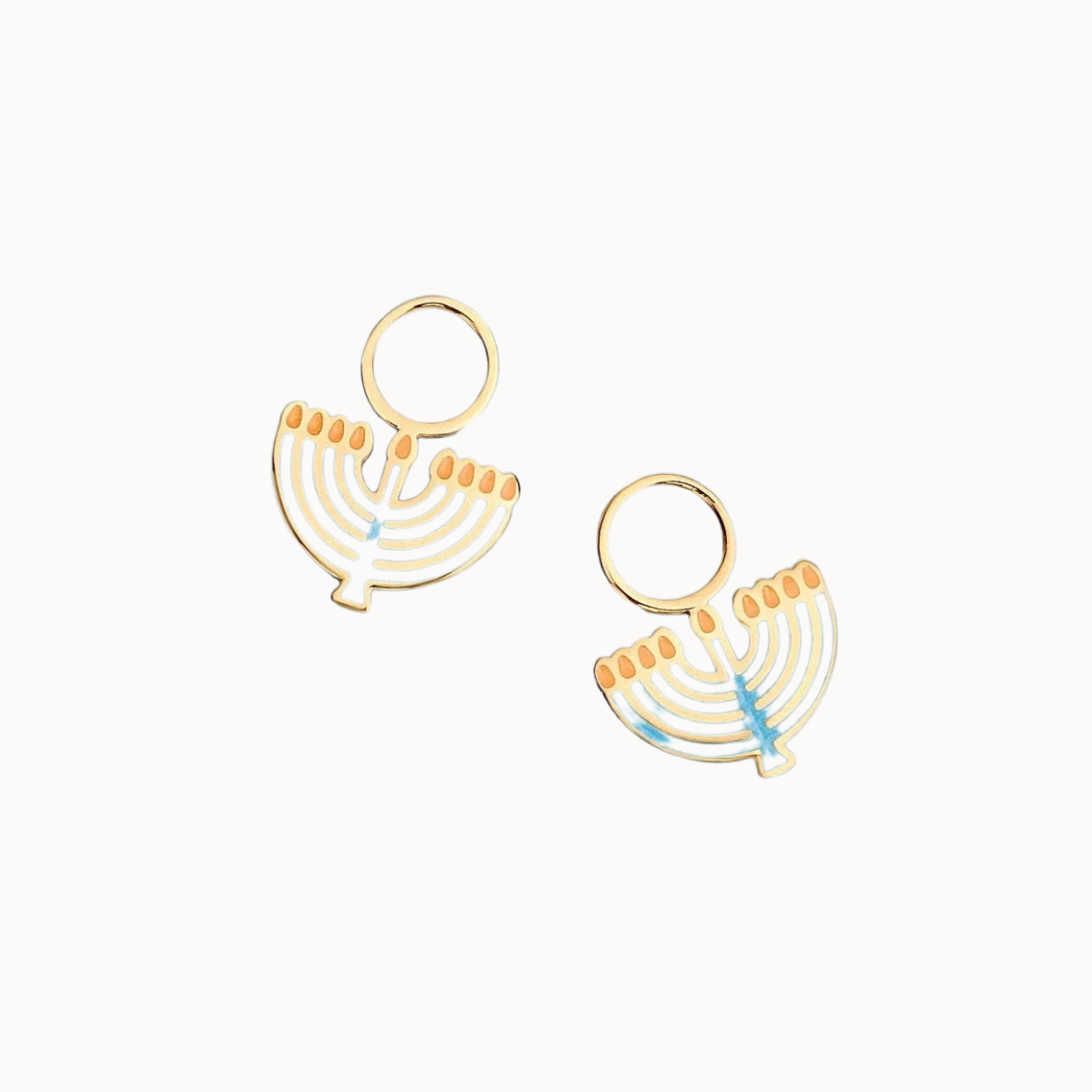A pair of gold-tone menorah-shaped earrings with light blue and orange enamel details, displayed on a solid off white background.