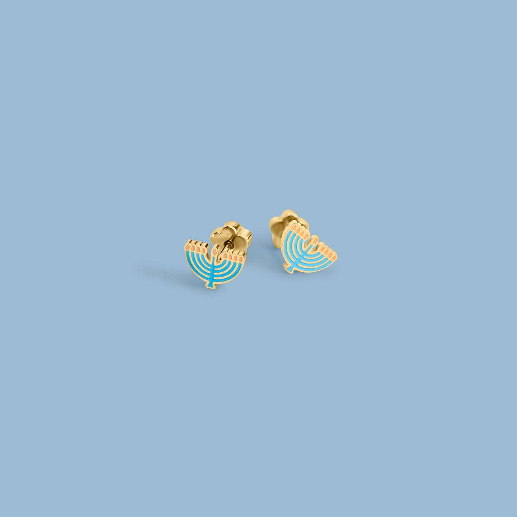 A pair of gold-tone menorah stud earrings with light blue enamel details, shown on a solid light blue background.