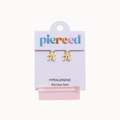 A pair of gold-plated stainless steel pi symbol stud earrings on a white display card with the brand name 'pierced' in multicolored letters. The card also reads 'HYPOALLERGENIC Stainless Steel' and is displayed on a pink stand against a light off-white background.