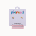 Two small gold stud earrings shaped like the Greek letter pi (π) on a lavender Piered brand display card with a pink stand, photographed on a light gray background.