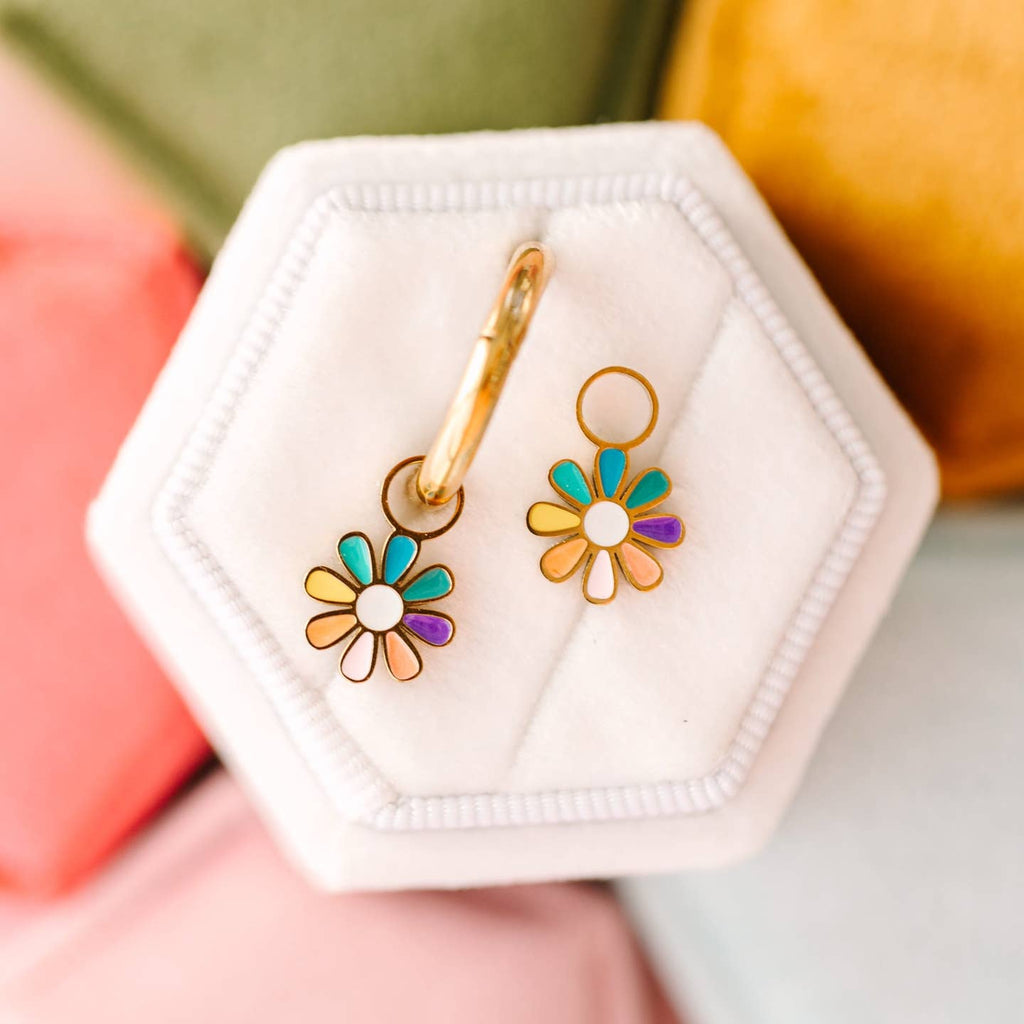 Colorful flower-shaped earrings in a hexagonal white jewelry box.
