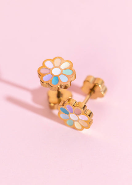 Colorful flower-shaped earrings on a pink background