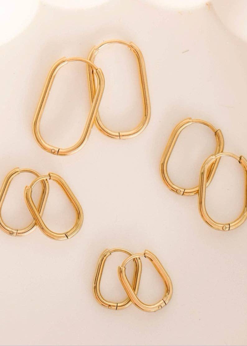Gold hoop earrings on a light beige background