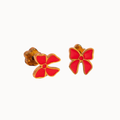 A pair of gold-tone stud earrings shaped like stylized flowers with bright red enamel petals, shown on a plain off-white background.