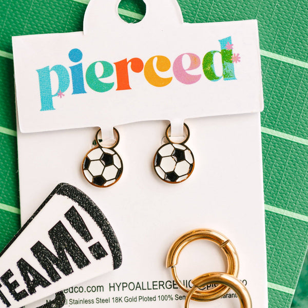 Soccer ball-shaped earrings on a 'pierced' card with branding details.