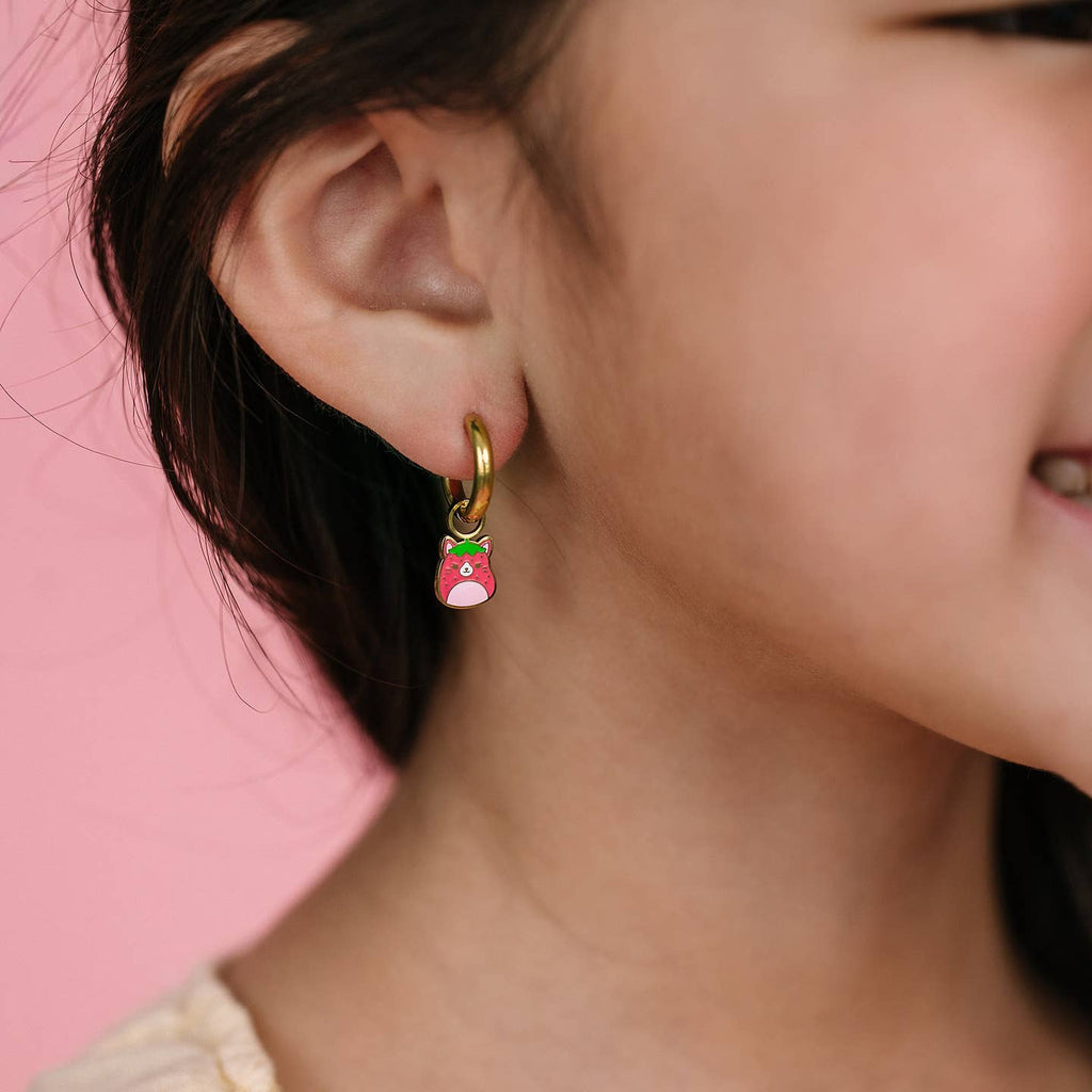 Close-up of a person wearing a colorful earring against a pink background