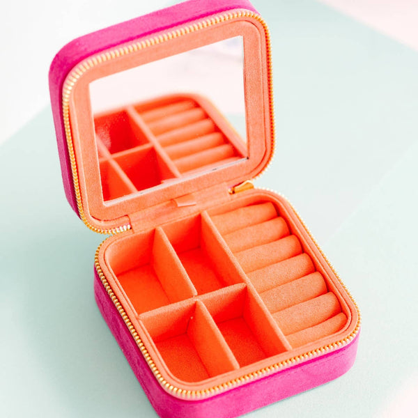 Pink jewelry box with compartments on a light blue background