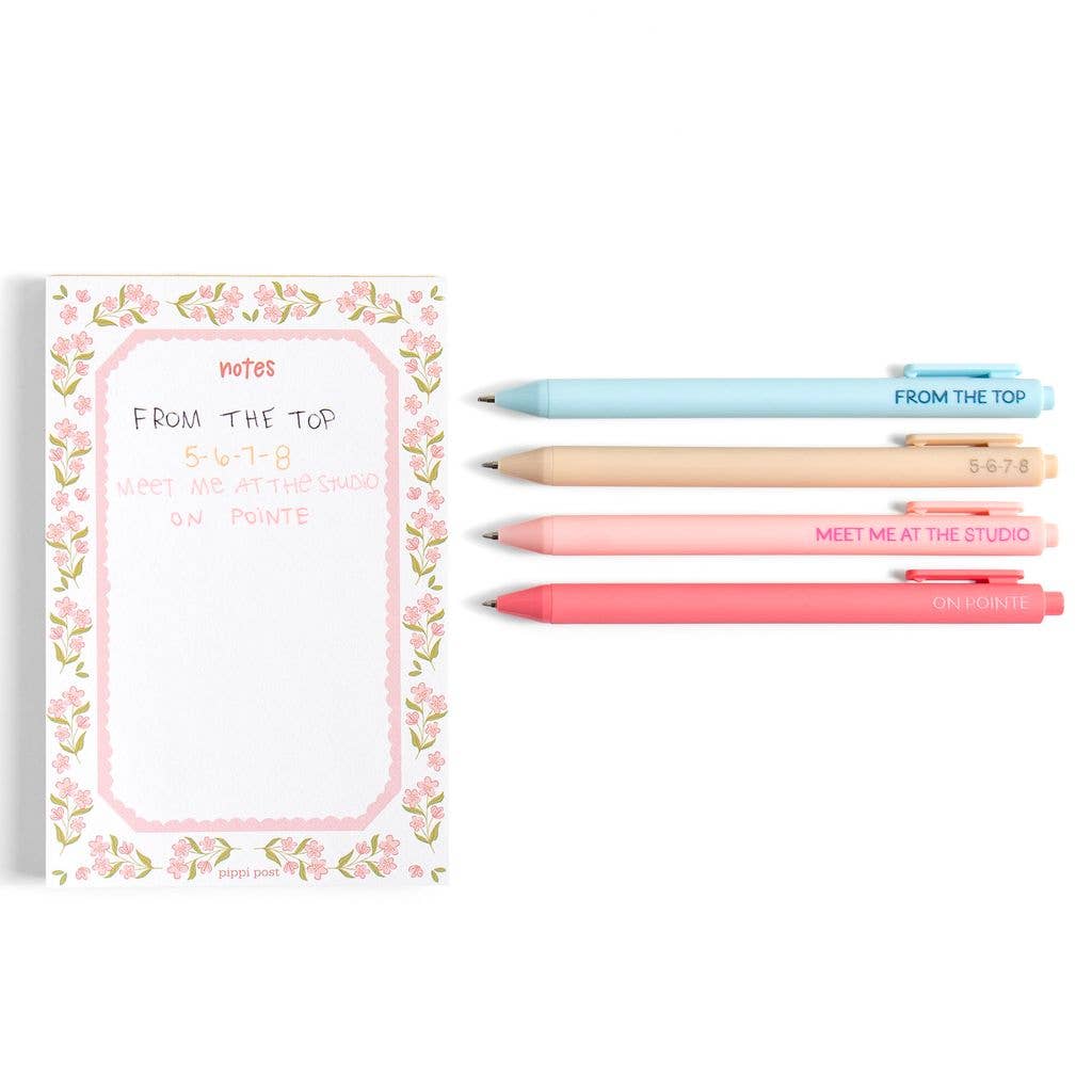 Floral notebook with four pens on a white background