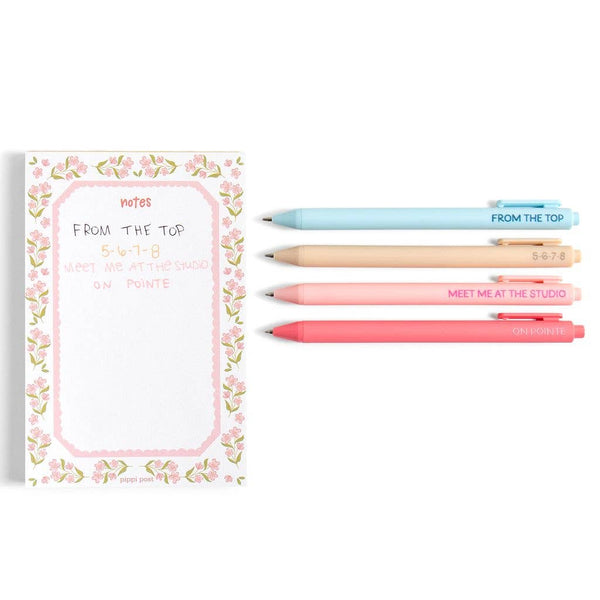 Floral notebook with four pens on a white background